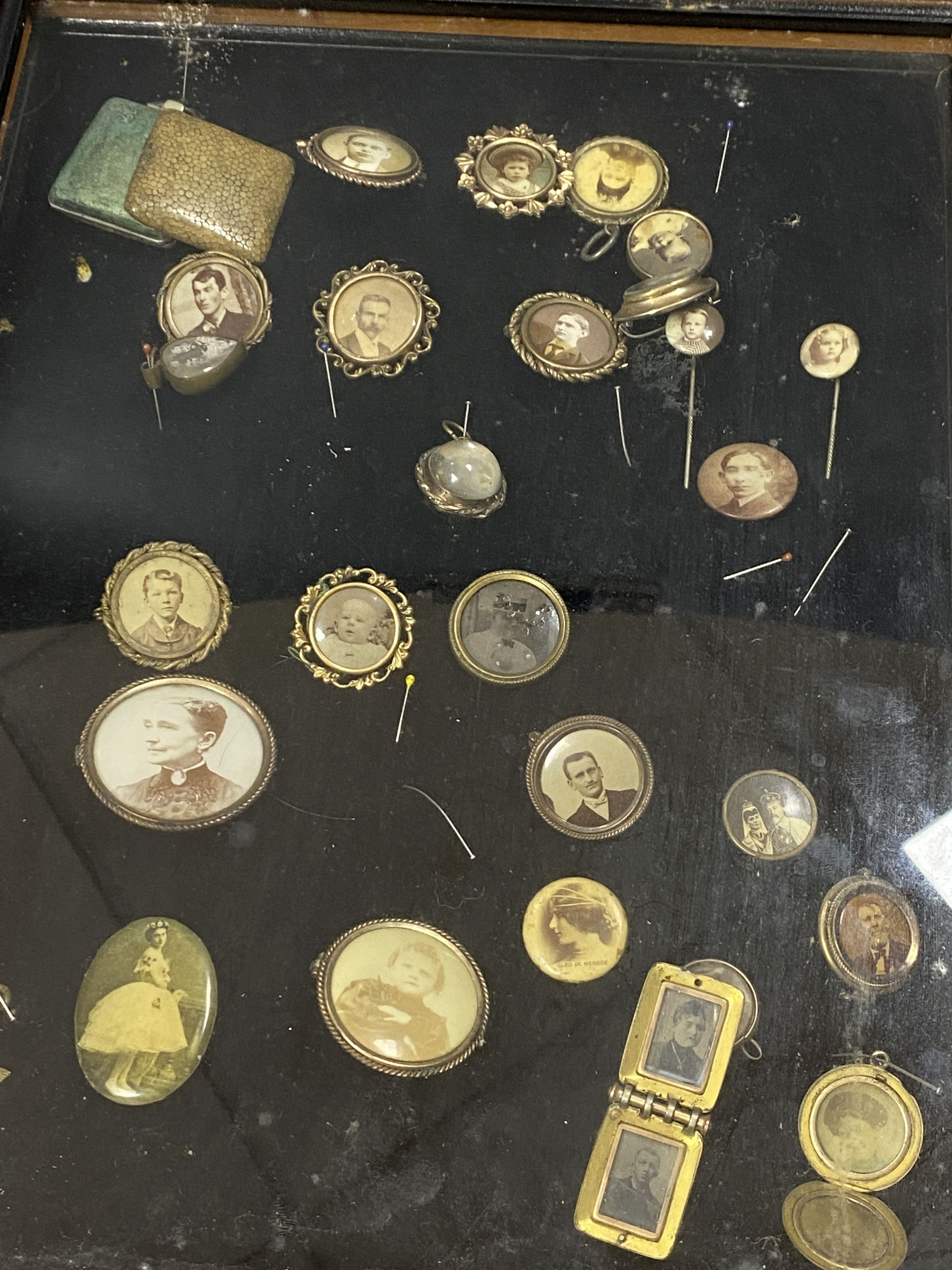 A collection of gilt metal stick pins, brooches, etc. with inset photographic miniatures in glazed case